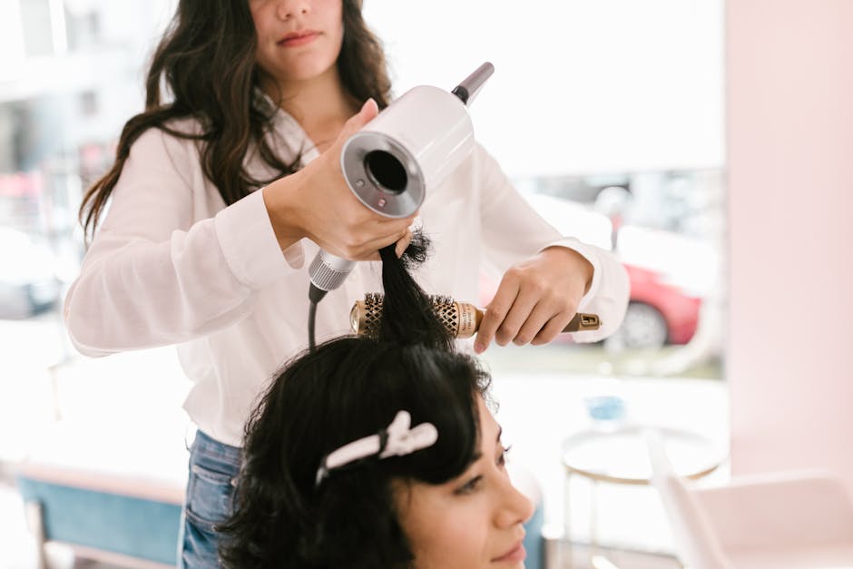 Woman getting her hair styled by a professional hairdresser in a chic modern salon